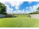 Backyard featuring lush grass, mature trees, and a fenced perimeter, offering privacy and outdoor enjoyment at 7952 Oakstone Ct, Orlando, FL 32822