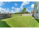 Backyard featuring lush grass, mature trees, and a fenced perimeter, offering privacy and outdoor enjoyment at 7952 Oakstone Ct, Orlando, FL 32822