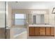 Well-lit bathroom features double vanity, soaking tub and tiled walls at 7952 Oakstone Ct, Orlando, FL 32822