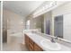 Bright bathroom featuring double sinks, a large mirror, and a relaxing bathtub at 7952 Oakstone Ct, Orlando, FL 32822