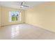 Bright bedroom featuring tile flooring, a ceiling fan, and a sunlit window, offering a serene and comfortable space at 7952 Oakstone Ct, Orlando, FL 32822