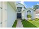 Close-up of the light blue home's elegant front entrance, accented with a tiled walkway at 7952 Oakstone Ct, Orlando, FL 32822