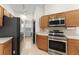 Functional kitchen featuring stainless steel appliances, wood cabinetry, and tiled flooring at 7952 Oakstone Ct, Orlando, FL 32822
