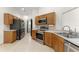 Functional kitchen featuring stainless steel appliances, wood cabinetry, and tiled flooring at 7952 Oakstone Ct, Orlando, FL 32822