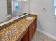 Bathroom with a granite vanity, decorative mirror, and a tiled shower at 8994 Fort Jefferson Blvd, Orlando, FL 32822