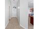 Hallway with neutral tile flooring leading to the front door and a glimpse of the kitchen at 8994 Fort Jefferson Blvd, Orlando, FL 32822