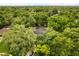 An aerial view of a home surrounded by lush green trees with a screened pool in the backyard at 917 Southern Oak Ln, Apopka, FL 32712