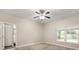 Neutral bedroom featuring a ceiling fan, a large window, and carpeted floors at 917 Southern Oak Ln, Apopka, FL 32712