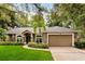 Inviting single-story home with a well-manicured lawn and an attached two-car garage at 917 Southern Oak Ln, Apopka, FL 32712