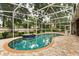 Sparkling screened-in pool with brick-paved deck and lush landscaping at 917 Southern Oak Ln, Apopka, FL 32712
