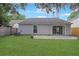 Well-maintained backyard showing the home's exterior, lawn, patio area, and perimeter wooden privacy fence at 1026 Mccully Ct, Oviedo, FL 32765