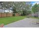 Spacious backyard with lush green grass, wood fence, and a concrete patio at 1026 Mccully Ct, Oviedo, FL 32765