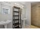 Bright bathroom with dual sinks, a shower with neutral colored tiling and a wooden shelf at 1026 Mccully Ct, Oviedo, FL 32765