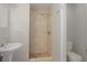 Neutral-tiled shower stall and pedestal sink in the updated bathroom at 1026 Mccully Ct, Oviedo, FL 32765