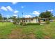 The home has a spacious backyard with a covered parking area with mature landscaping at 110 N Sunland Dr, Sanford, FL 32773