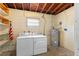 Unfinished basement featuring laundry area, utility connections, and exposed ceiling with water heater at 110 N Sunland Dr, Sanford, FL 32773