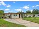 Inviting home exterior with a covered carport, tidy landscaping, and a lush green lawn at 110 N Sunland Dr, Sanford, FL 32773
