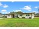 Well-kept home featuring a green lawn, complemented by a tidy landscape and neutral color palette at 110 N Sunland Dr, Sanford, FL 32773