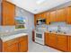 Functional kitchen with modern appliances, wooden cabinets, and a window overlooking the backyard at 110 N Sunland Dr, Sanford, FL 32773
