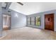 Bright living area with a large window, a neutral carpet, and a classic wooden front door at 110 N Sunland Dr, Sanford, FL 32773