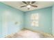 Bedroom with blue walls, a ceiling fan, a window and a stained concrete floor at 1212 N Hudson St, Orlando, FL 32808