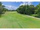 Scenic golf course view featuring lush green fairways and mature trees against a partly cloudy sky at 1224 Northern Way, Winter Springs, FL 32708