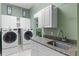 Bright laundry room features modern appliances, granite countertops, and ample cabinet space at 1224 Northern Way, Winter Springs, FL 32708