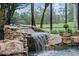 Beautiful rock waterfall in the screened pool area adding a natural water feature at 1224 Northern Way, Winter Springs, FL 32708
