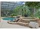 A screened pool and spa are surrounded by lush tropical landscaping at 1224 Northern Way, Winter Springs, FL 32708