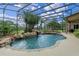 Screened in pool features lush landscaping, rock waterfall, and stone trim at 1224 Northern Way, Winter Springs, FL 32708