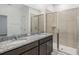 Bathroom boasting a dual sink granite vanity, a large mirror, and a glass-enclosed shower at 1323 Wood Line Dr, Deland, FL 32720