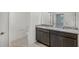 Bathroom featuring a granite countertop vanity with dual sinks, and a separate toilet room at 1323 Wood Line Dr, Deland, FL 32720