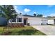 Charming single-story home with a manicured lawn, brick accents, and a three-car garage at 1323 Wood Line Dr, Deland, FL 32720