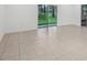 Expansive living area featuring neutral tile flooring and sliding glass doors to the backyard at 1323 Wood Line Dr, Deland, FL 32720