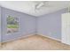 This bedroom is complete with carpeting, a ceiling fan, and a large window at 1406 Kissimmee Ct, Kissimmee, FL 34759