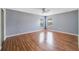 Bright bedroom features hardwood floors, neutral walls, and natural light from two windows at 1406 Kissimmee Ct, Kissimmee, FL 34759