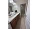 This bathroom boasts dual sinks, wooden cabinets, a large mirror and a glass door shower at 1452 Moon Valley Dr, Davenport, FL 33896