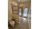 Well-lit bathroom featuring a glass enclosed shower, toilet and access to the yard at 1452 Moon Valley Dr, Davenport, FL 33896