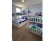 This bedroom is furnished with three bunk beds, blue bedding and 'Frozen' wall decor at 1452 Moon Valley Dr, Davenport, FL 33896