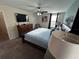 Comfortable bedroom featuring a ceiling fan, TV, and large bed covered in sunlight at 1452 Moon Valley Dr, Davenport, FL 33896
