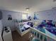 This bedroom is furnished with three bunk beds, blue bedding and cartoon wall decor at 1452 Moon Valley Dr, Davenport, FL 33896
