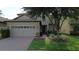 Attractive home with a brick driveway, a two-car garage, and neat landscaping at 1452 Moon Valley Dr, Davenport, FL 33896