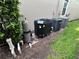 HVAC unit behind home next to a bush and maintained green lawn at 1452 Moon Valley Dr, Davenport, FL 33896