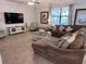 Spacious living room with a large sectional couch, media center, and coastal-themed decor for comfortable living at 1452 Moon Valley Dr, Davenport, FL 33896