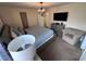 This main bedroom features a chandelier, a flatscreen TV and a cozy chair at 1452 Moon Valley Dr, Davenport, FL 33896