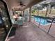 A covered patio with a dining table, seating area, and view of a screened-in pool at 1452 Moon Valley Dr, Davenport, FL 33896