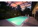 Relaxing pool with a screened enclosure, hot tub, and lush greenery at 1452 Moon Valley Dr, Davenport, FL 33896