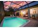 Evening view of a screened in pool with spa and an outdoor seating area at 1452 Moon Valley Dr, Davenport, FL 33896