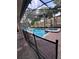 A screened pool and attached hot tub with brick pavers and palm trees at 1452 Moon Valley Dr, Davenport, FL 33896