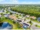 An aerial shot displays this home's solar panels, pool, landscaping, and proximity to a lake and a lush tree line at 14634 Astina Way, Orlando, FL 32837